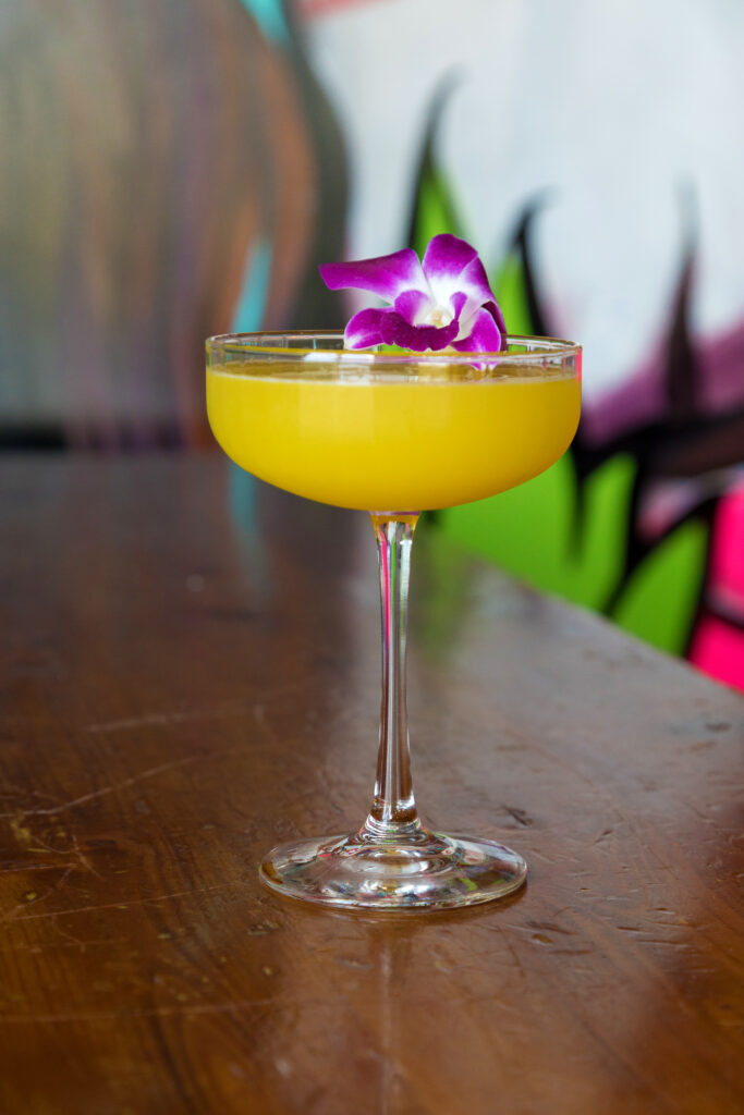 Handcrafted cocktail garnished with an orchid at Señor Taps